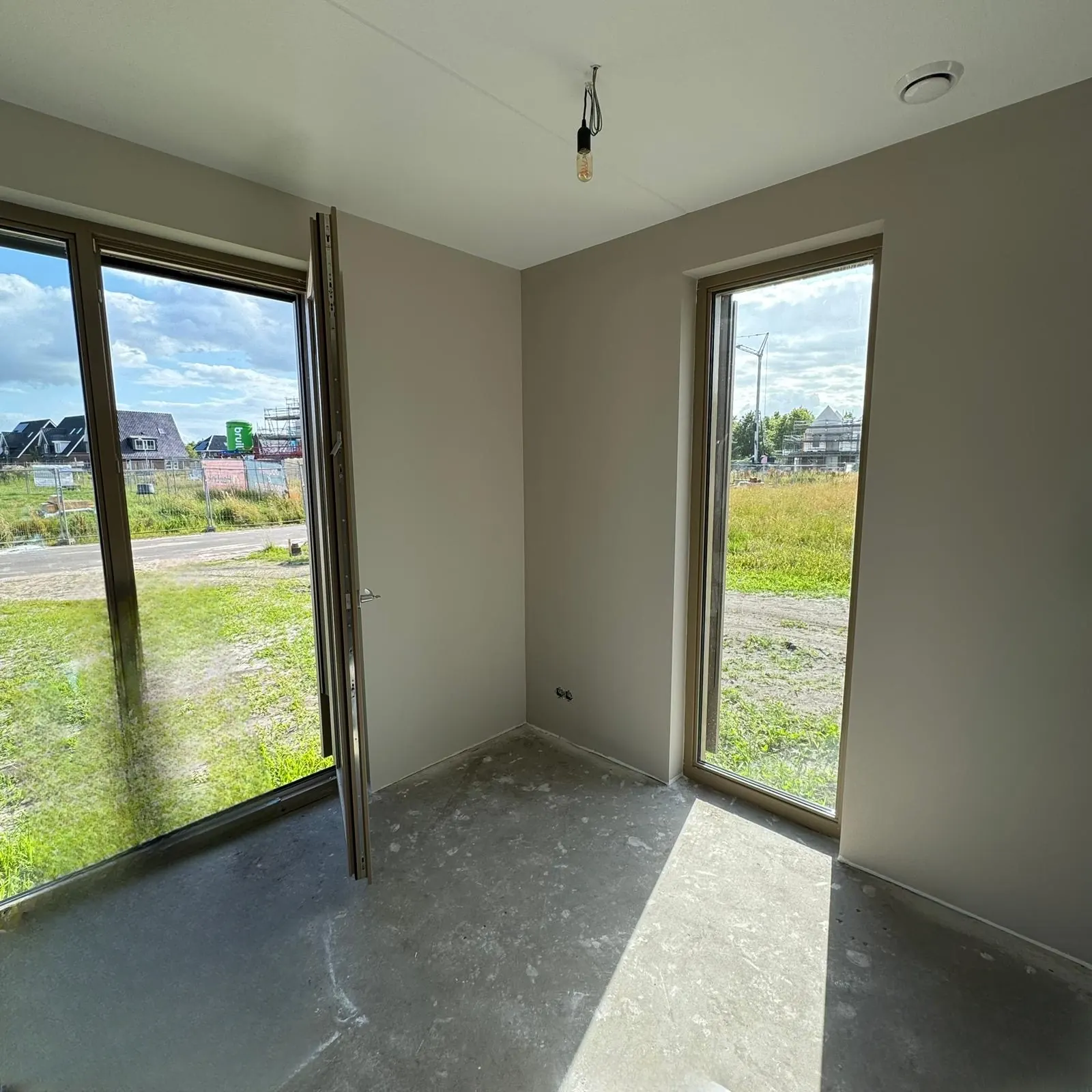 Kamer met tuindeuren in een nieuwbouwwoning, Leek