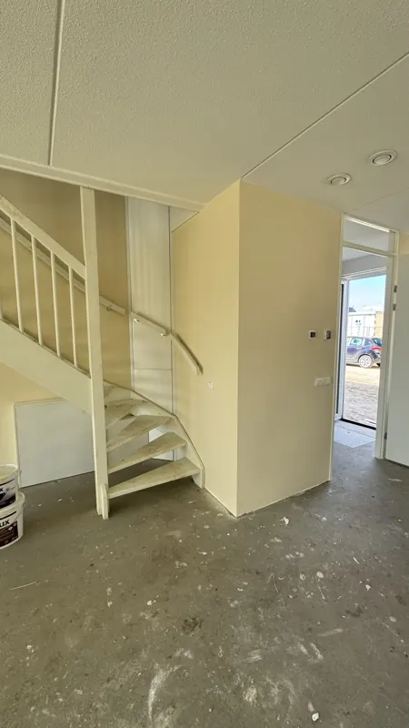Hal en trap van een nieuwbouwwoning na de wandafwerking, project Luttelgeest