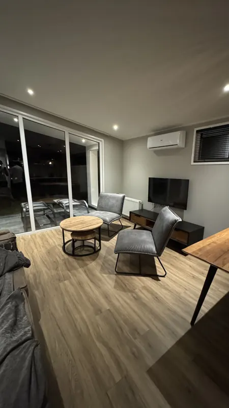 Woonkamer met strak afgewerkte wanden na renovatie, project Putte