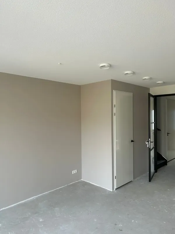 Woonkamer met gesausde taupe wanden na renovlies, project Zevenhuizen