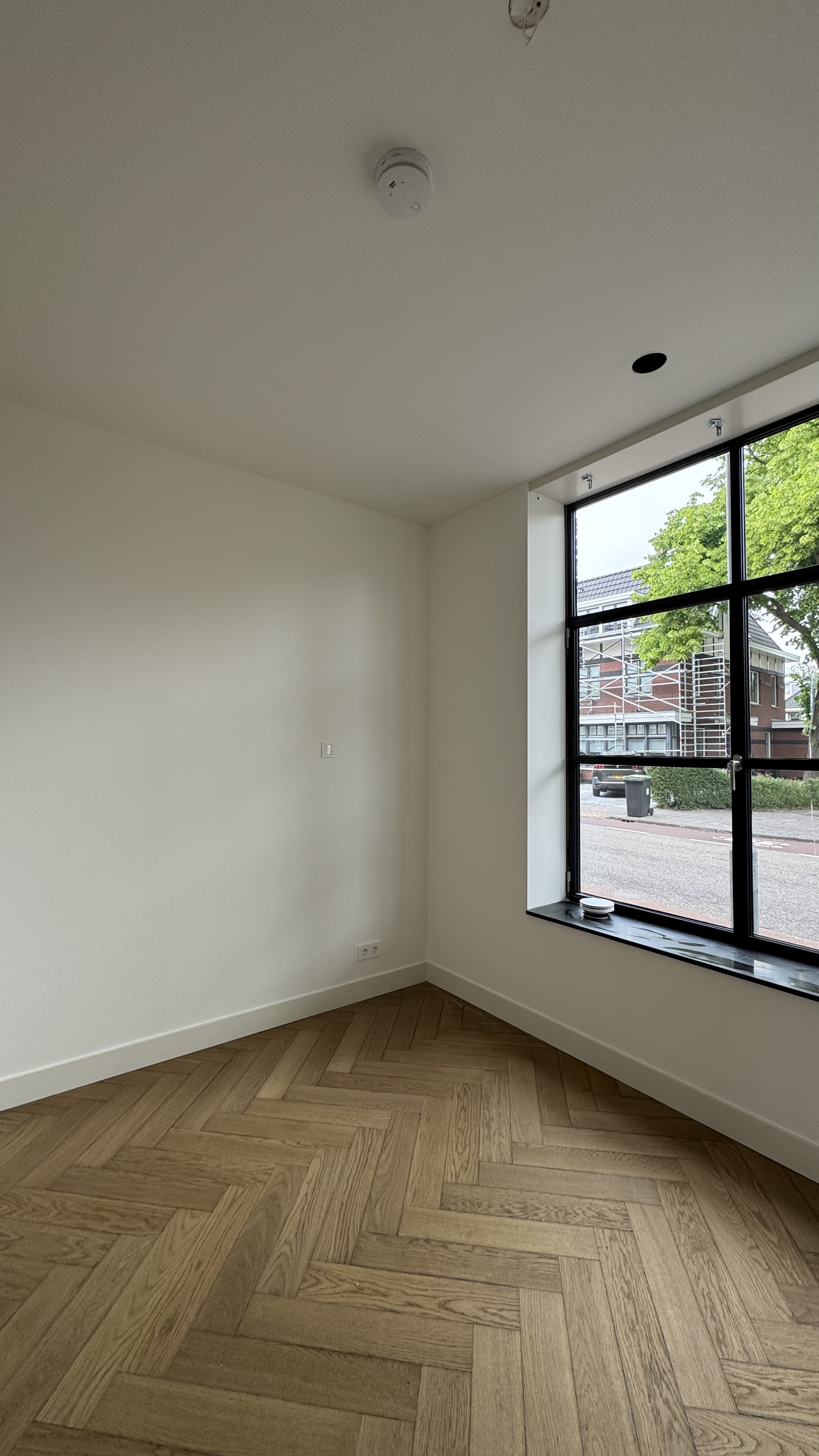 Eetkamer met visgraatvloer en wit geschilderd plafond Haarlem