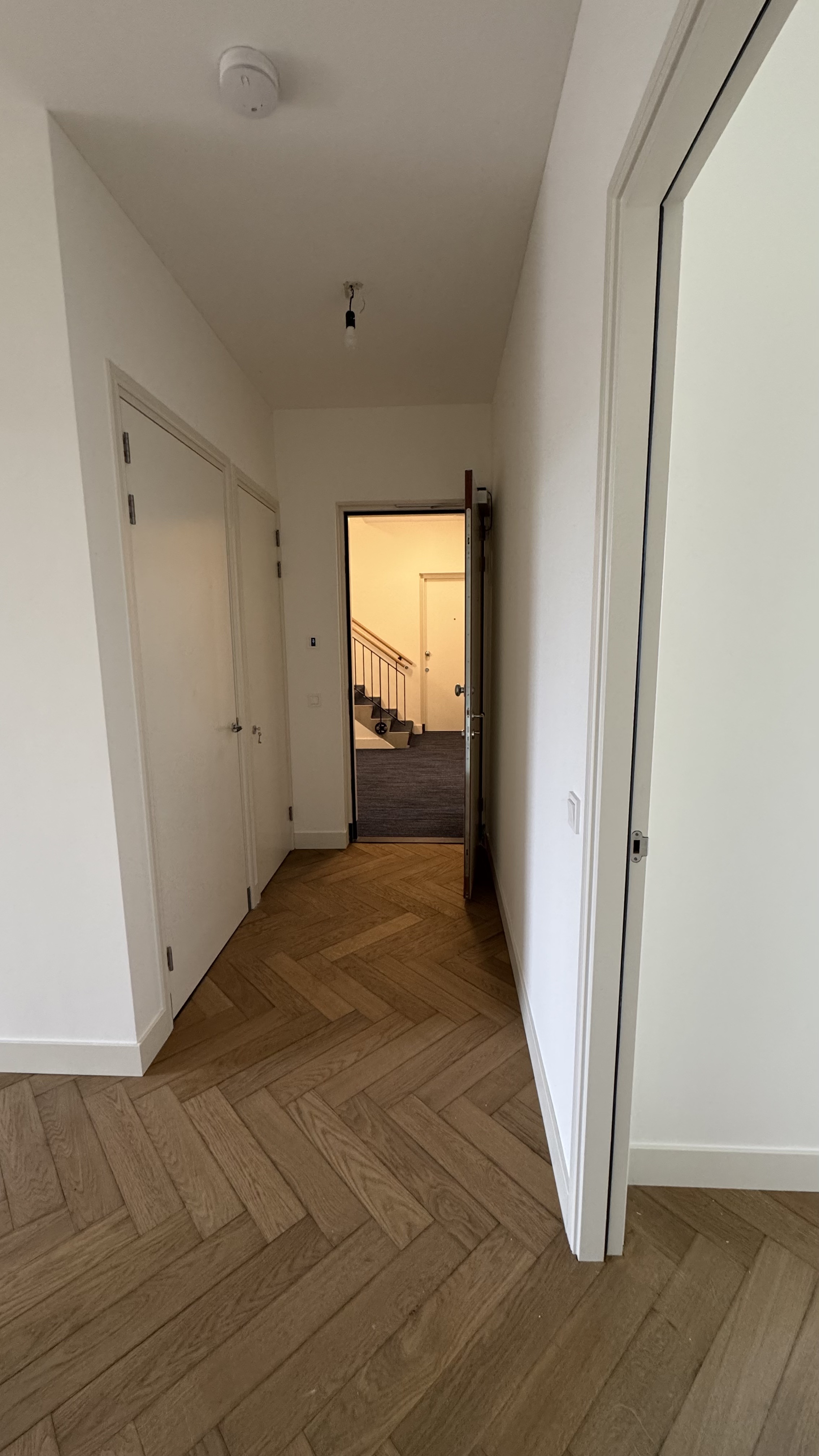 Traphal en overloop met professioneel schilderwerk renovatie Haarlem