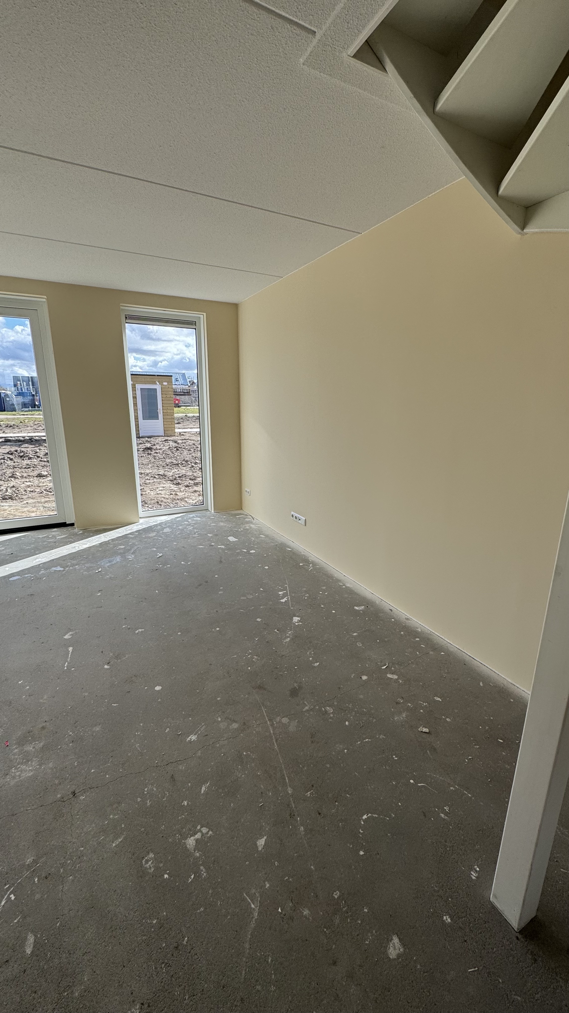 Hal met trap en strakke witte muren na renovlies afwerking nieuwbouw Luttelgeest Flevoland